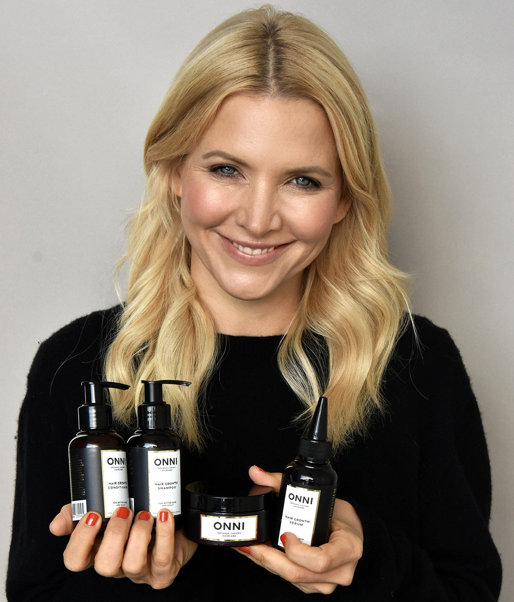 Frau hält das ONNI Haarpflege Set mit Shampoo, Conditioner, Maske und Serum