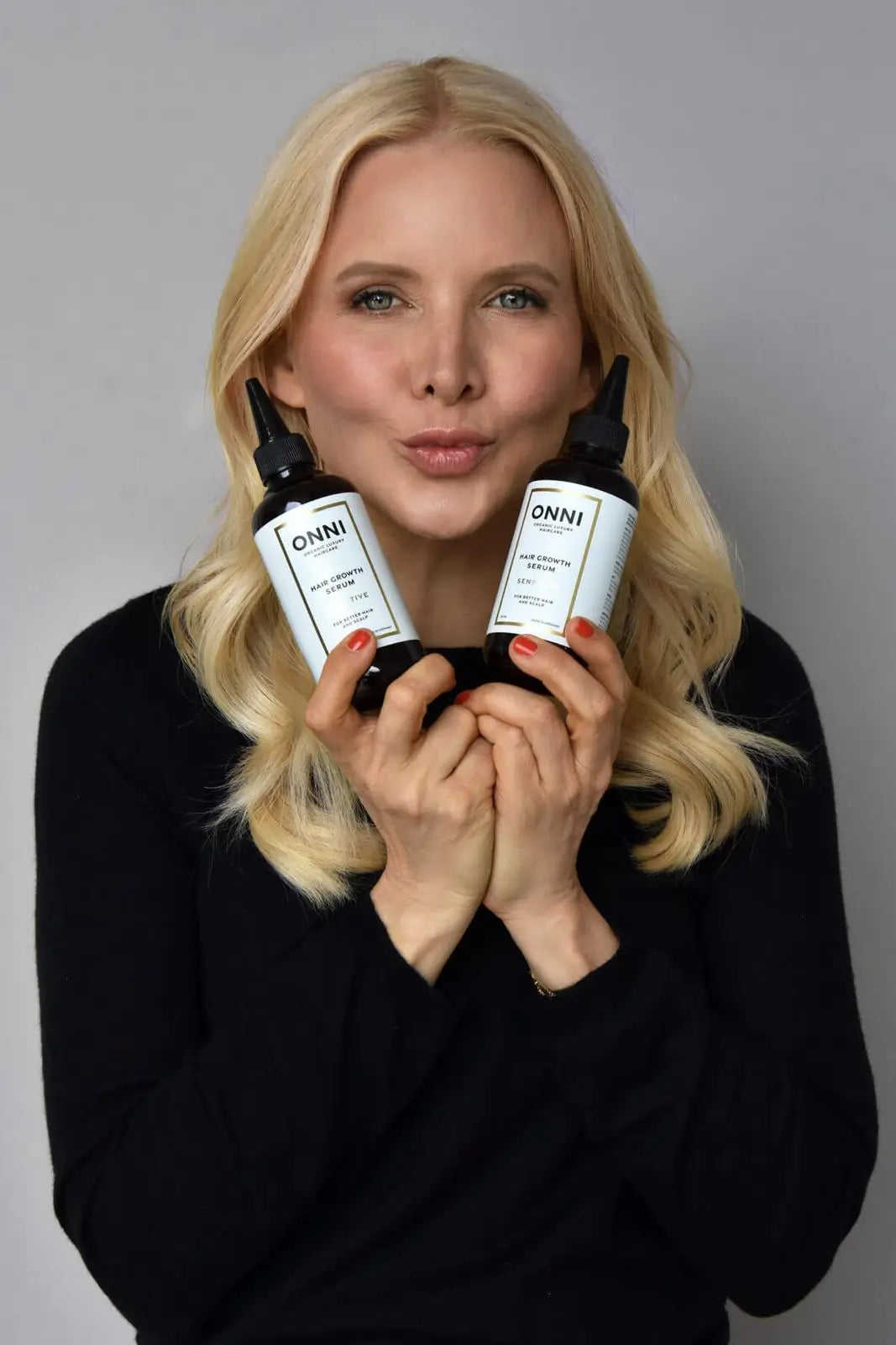 Stefanie Wirnshofer mit zwei ONNI Hair Growth Serum Flaschen